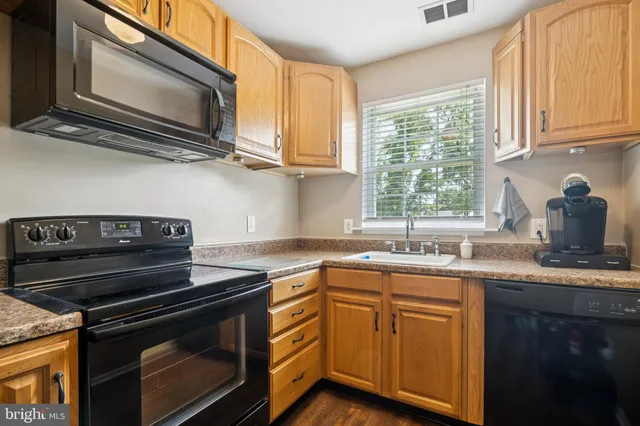 a kitchen with granite countertop a stove sink and microwave