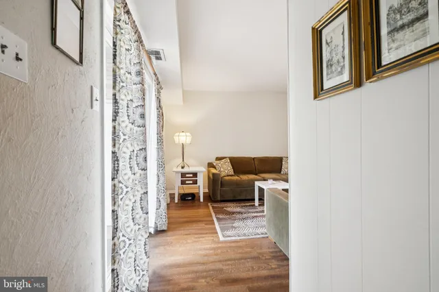 a living room with furniture and a painting on the wall