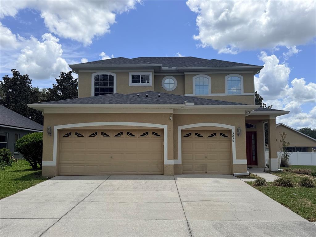 13250 Mandalay Place Spring Hill, FL 34609 - Photo 1 of 28 a front view of a house with a yard and garage