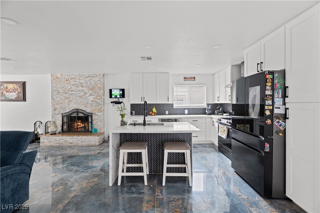 4231 Rimcrest Road Las Vegas, NV 89121 - Photo 52 of 52 Kitchen with open floor plan, freestanding refrigerator, marble tiled flooring, backsplash, and white cabinets
