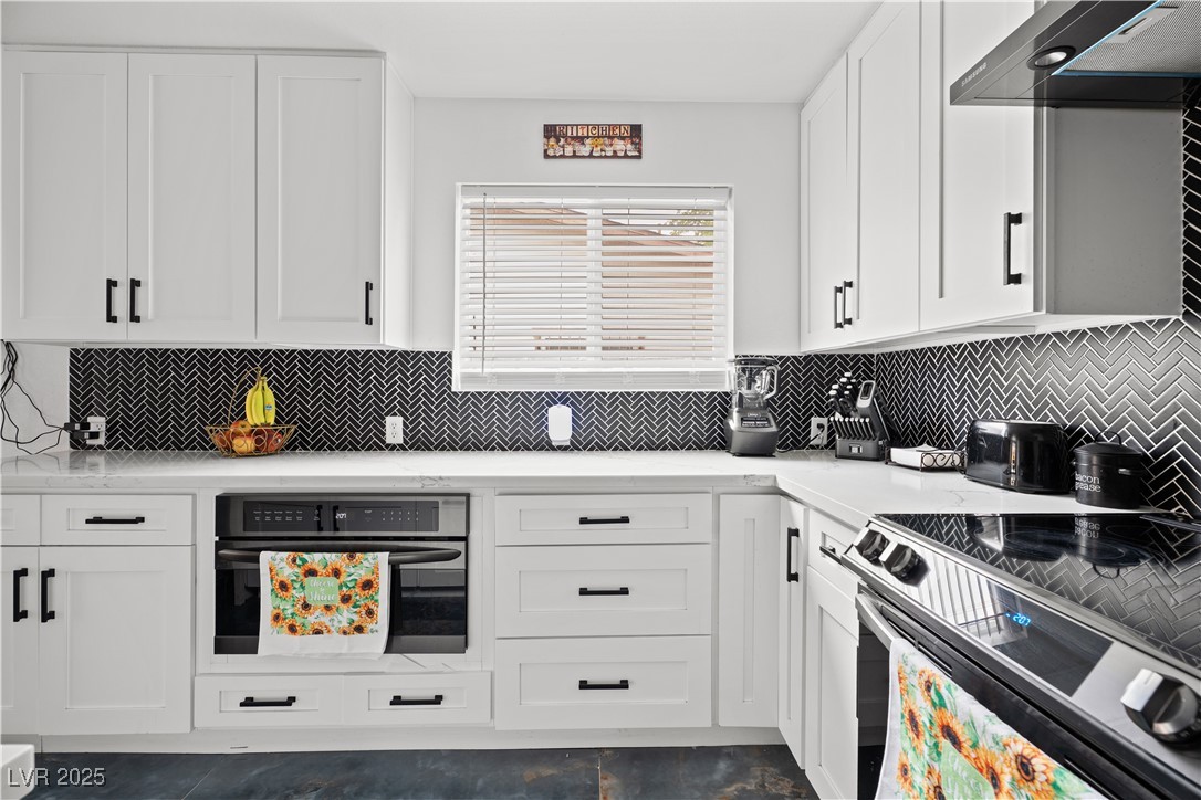 4231 Rimcrest Road Las Vegas, NV 89121 - Photo 14 of 52 Kitchen with stainless steel electric range oven, black oven, ventilation hood, and white cabinetry