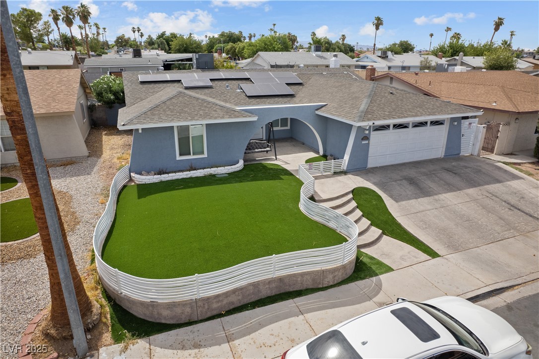 4231 Rimcrest Road Las Vegas, NV 89121 - Photo 2 of 52 View of front of home with a shingled roof, a residential view, solar panels, driveway, and a garage