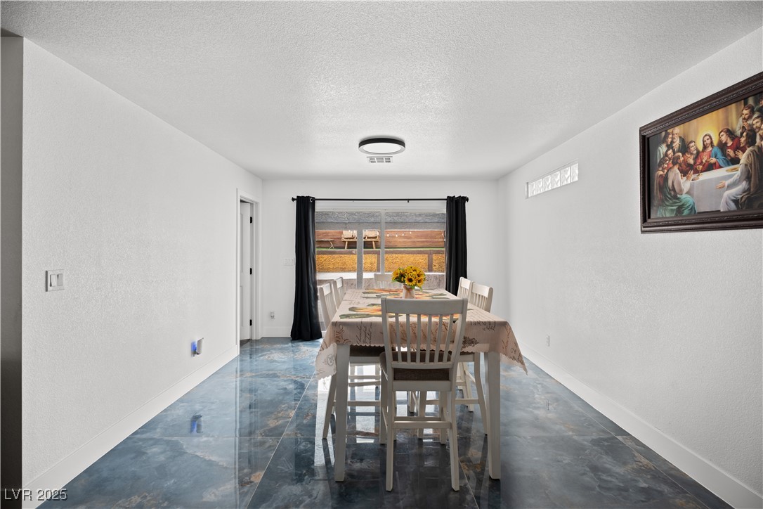 4231 Rimcrest Road Las Vegas, NV 89121 - Photo 21 of 52 Dining room featuring a textured ceiling and baseboards