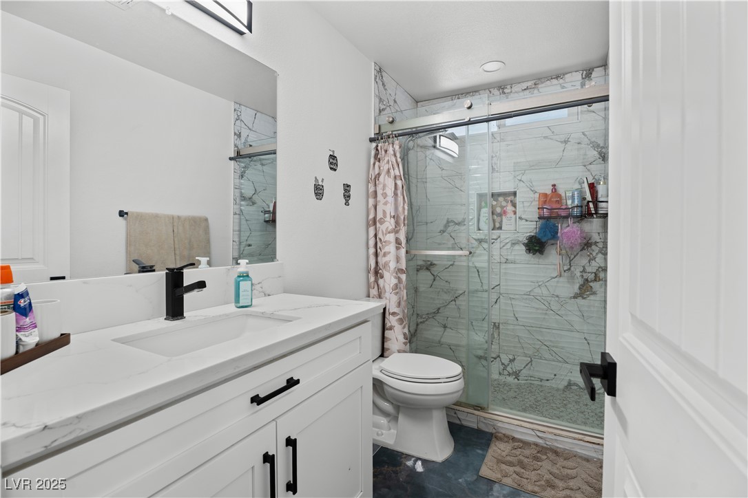 4231 Rimcrest Road Las Vegas, NV 89121 - Photo 27 of 52 Bathroom featuring a marble finish shower and vanity