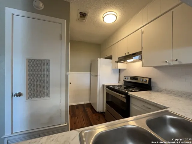 a kitchen with stainless steel appliances granite countertop a refrigerator and a sink