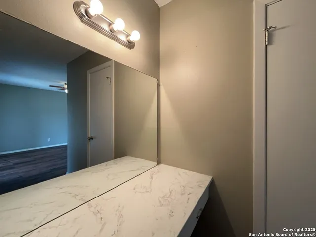 a bedroom with a bed and a chandelier fan