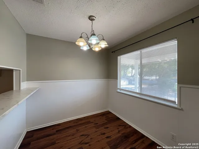 a view of a livingroom with wooden floor and a large window