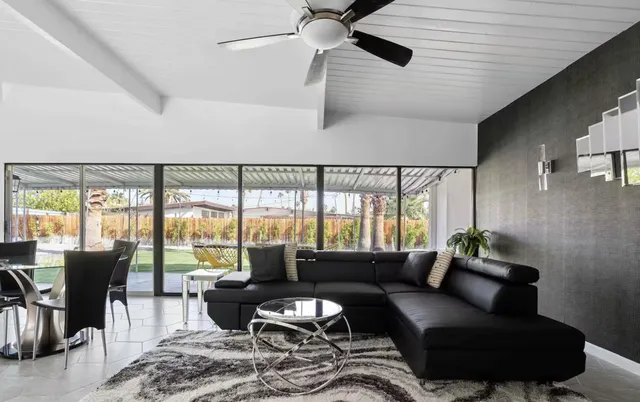 a living room with furniture and floor to ceiling windows