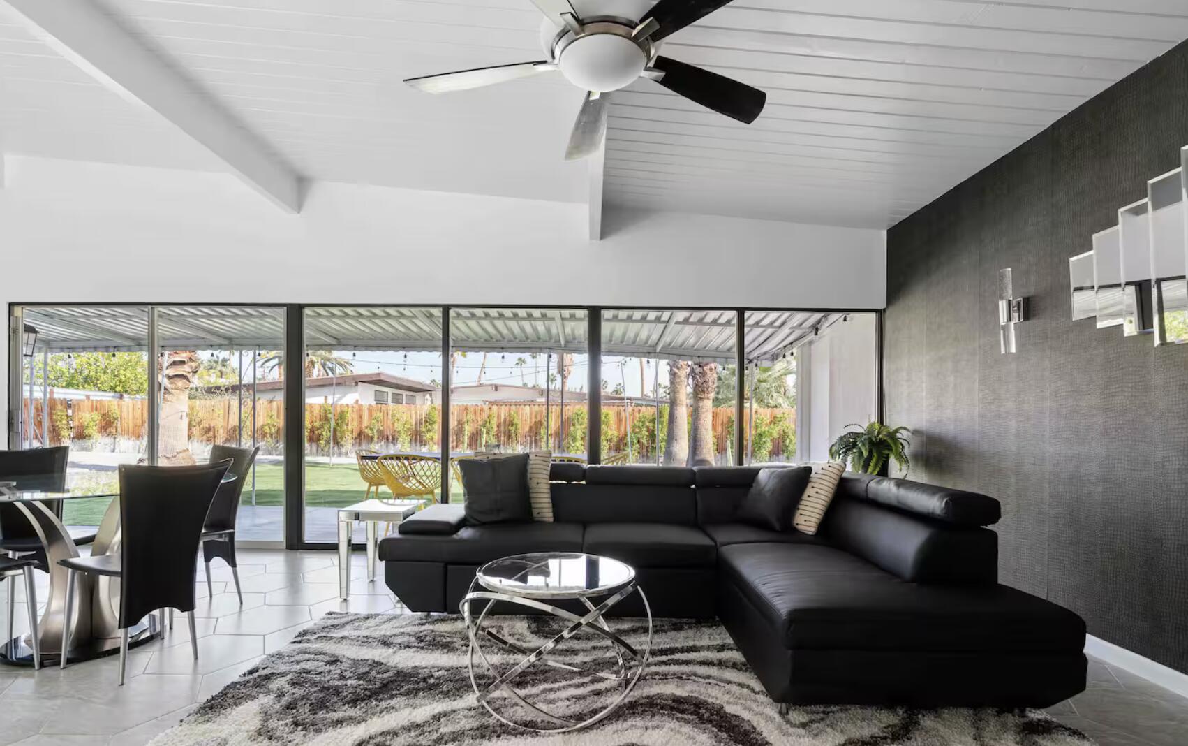 a living room with furniture and floor to ceiling windows