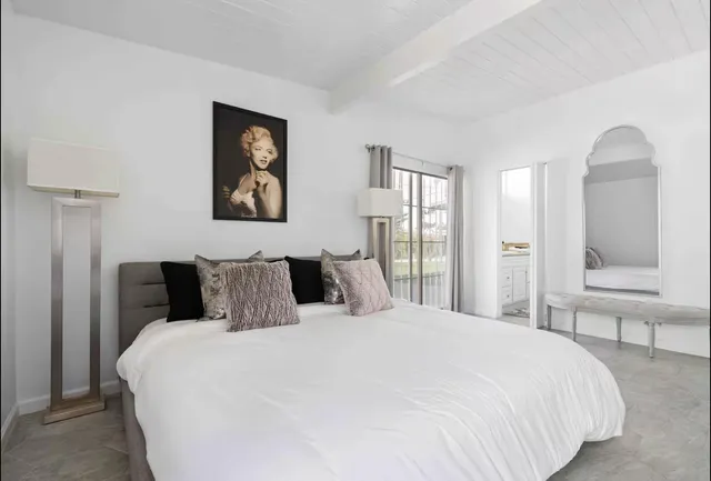 a bedroom with a large bed and a chandelier