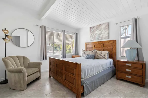 a bedroom with a bed a dresser and a couch