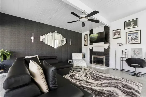 a living room with furniture a fireplace and a flat screen tv