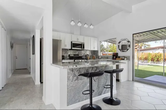 a kitchen with stainless steel appliances a stove a refrigerator and a sink