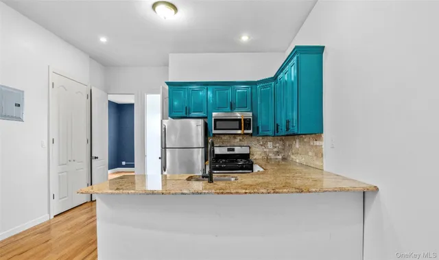 a kitchen with kitchen island a counter top space cabinets and stainless steel appliances