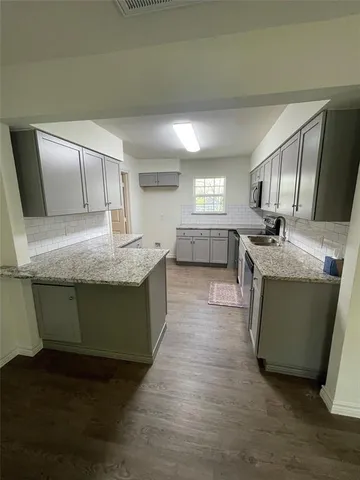 a kitchen with kitchen island a sink dishwasher stove and refrigerator with wooden floor