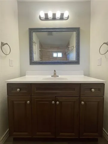 a bathroom with a sink vanity and mirror