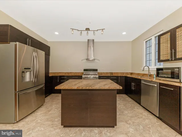 a kitchen with stainless steel appliances granite countertop a refrigerator and a sink