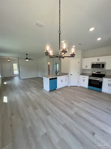 a view of a kitchen with a sink and an empty room
