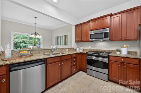 a kitchen with stainless steel appliances granite countertop a stove sink and microwave