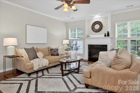 a living room with furniture a clock and a fireplace