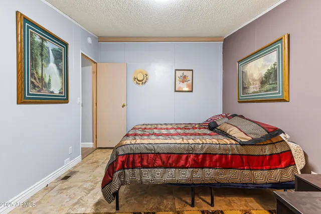a bedroom with a bed and painting on the wall