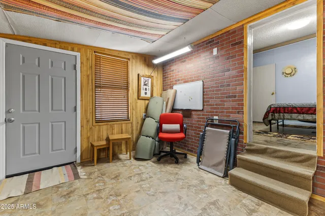 a view of a workspace with furniture and a window