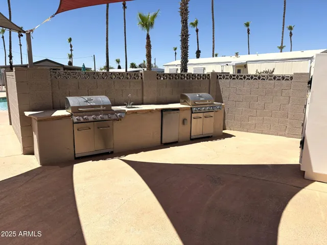 a kitchen with stainless steel appliances kitchen island granite countertop a sink a stove and a wooden floors
