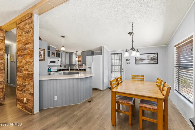 a kitchen with stainless steel appliances kitchen island granite countertop a table chairs and a refrigerator
