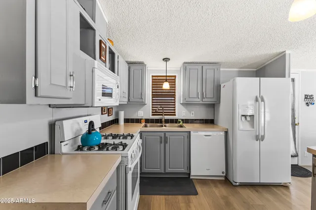 a kitchen with stainless steel appliances a stove a refrigerator a sink a counter space and cabinets