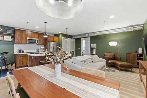 a kitchen with sink refrigerator dining table and chairs