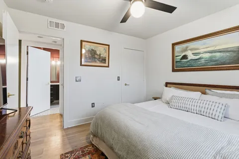 a bedroom with a bed and a painting on the wall