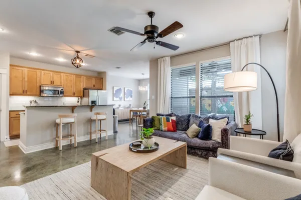 a living room with furniture kitchen view and a large window