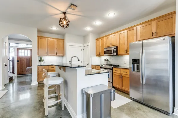a kitchen with stainless steel appliances granite countertop a sink stove and cabinets