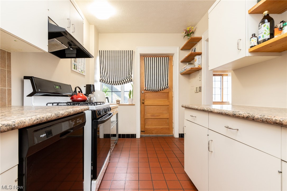 2515 Overlook Road, Unit 14 Cleveland, OH 44106 - Photo 6 of 20 Kitchen featuring white cabinets, dark tile floors, and gas stove