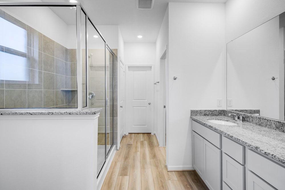 5606 Buttonbush Court Rosenberg, TX 77471 - Photo 11 of 34 a bathroom with a granite countertop sink a mirror and shower