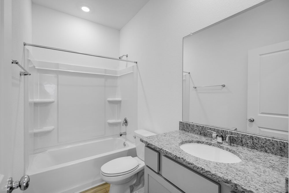 5606 Buttonbush Court Rosenberg, TX 77471 - Photo 17 of 34 a bathroom with a granite countertop sink toilet mirror and shower