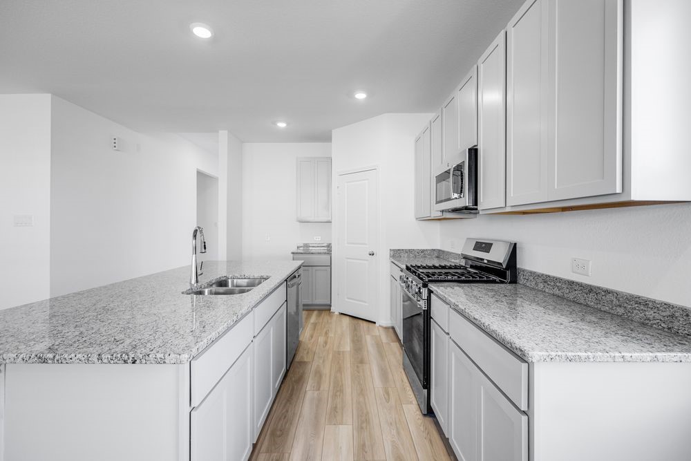 5606 Buttonbush Court Rosenberg, TX 77471 - Photo 2 of 34 a kitchen with granite countertop kitchen island stainless steel appliances a sink stove top oven and cabinets