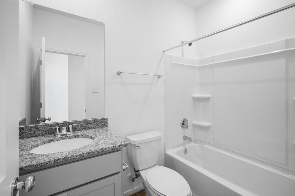 5606 Buttonbush Court Rosenberg, TX 77471 - Photo 25 of 34 a bathroom with a granite countertop sink toilet and shower