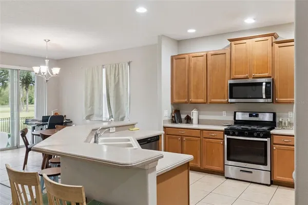 a kitchen with kitchen island granite countertop a sink and a refrigerator