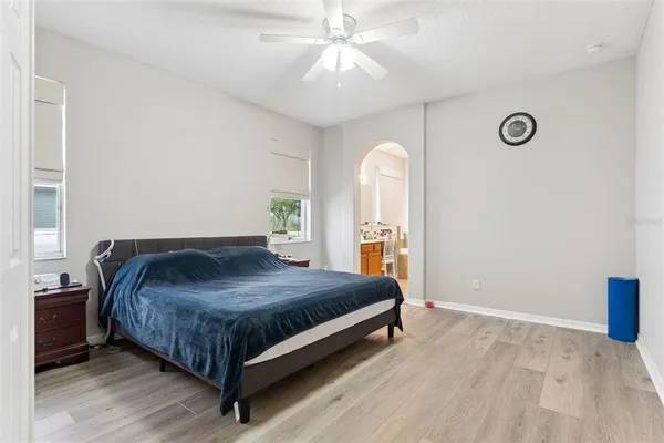 a bedroom with a bed and a chandelier fan