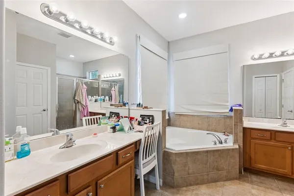 a bathroom with a tub sink and mirror