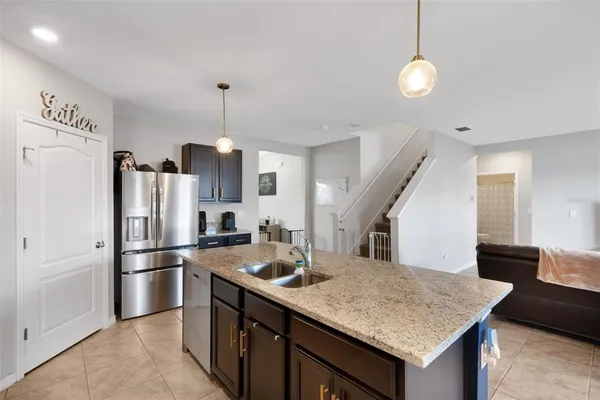 a kitchen with stainless steel appliances granite countertop a sink refrigerator and cabinets