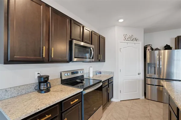 a kitchen with stainless steel appliances granite countertop a refrigerator microwave and sink