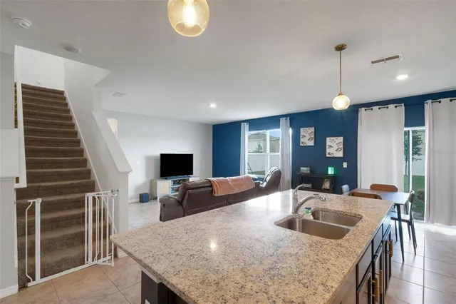a kitchen with sink refrigerator and couches