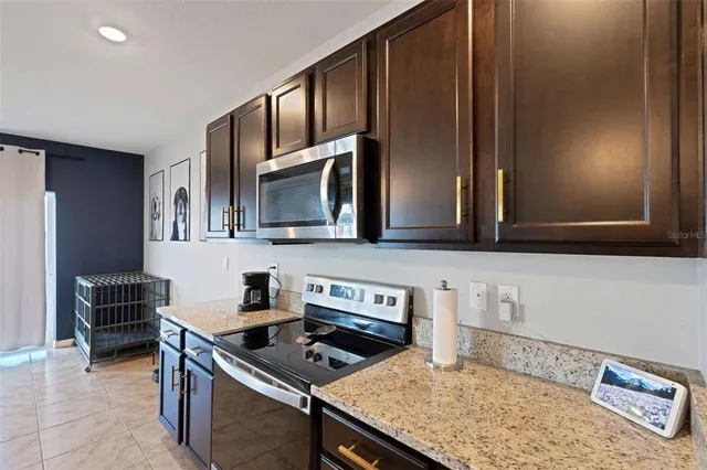 a kitchen with stainless steel appliances granite countertop a sink stove and microwave