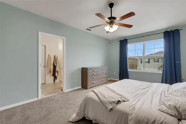 a bedroom with a large bed and a ceiling fan