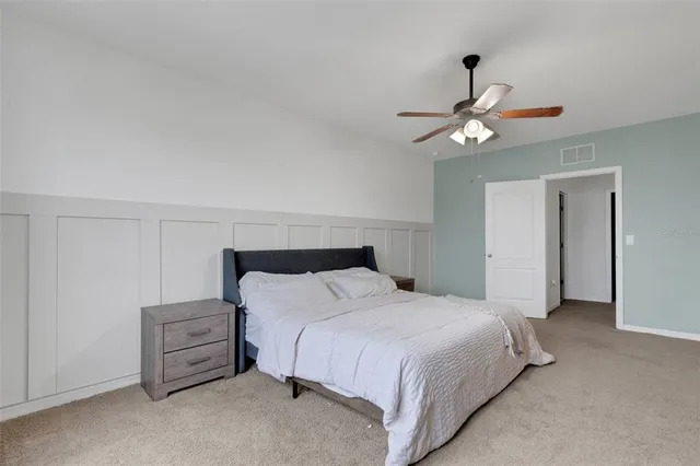 a bedroom with a bed and a ceiling fan