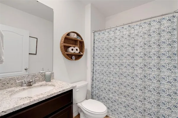 a bathroom with a granite countertop toilet sink and mirror