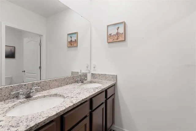 a bathroom with a granite countertop sink and a mirror