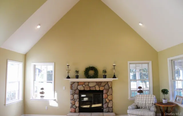 a bed sitting in a spacious bedroom next to a window with fireplace